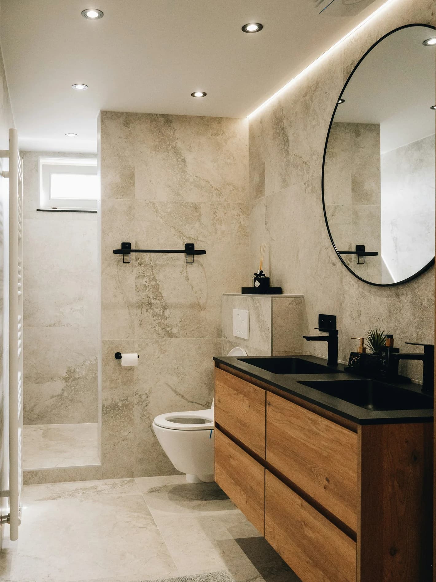 Bathroom finished with large-format stone-look porcelain tile, a curbless walk-in shower, and a floating wood vanity