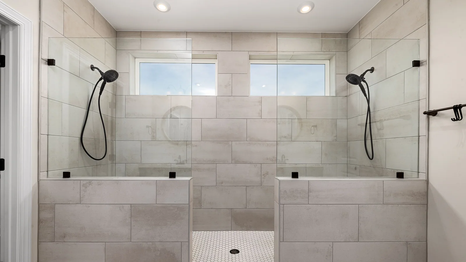 Double shower with large wall tile and a mosaic shower floor