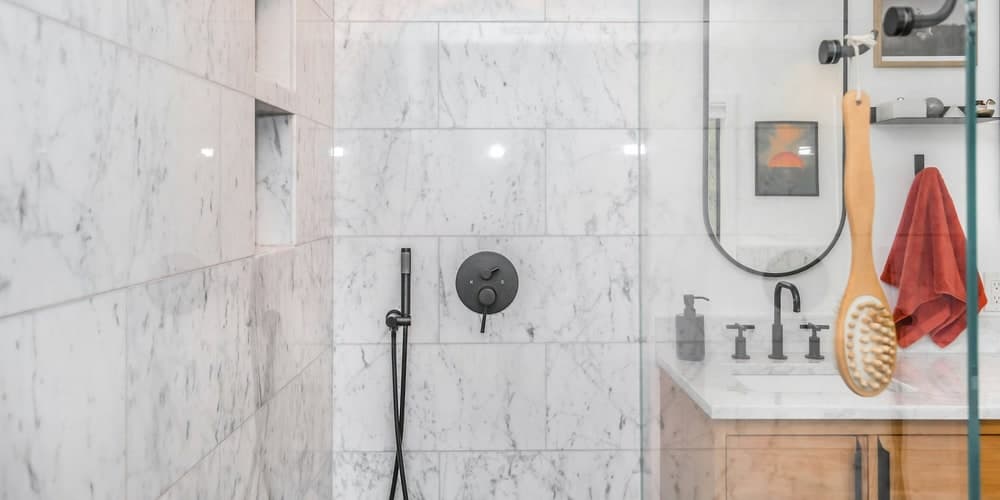 Walk-in shower tile installation with glass panels and mosaic shower floor
